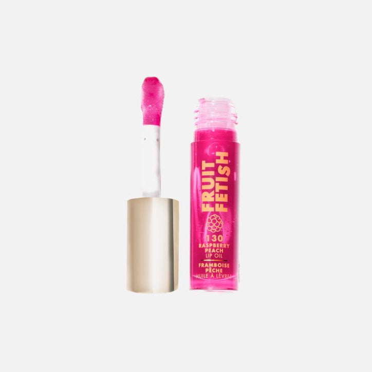 Pink lip gloss with applicator on a white background