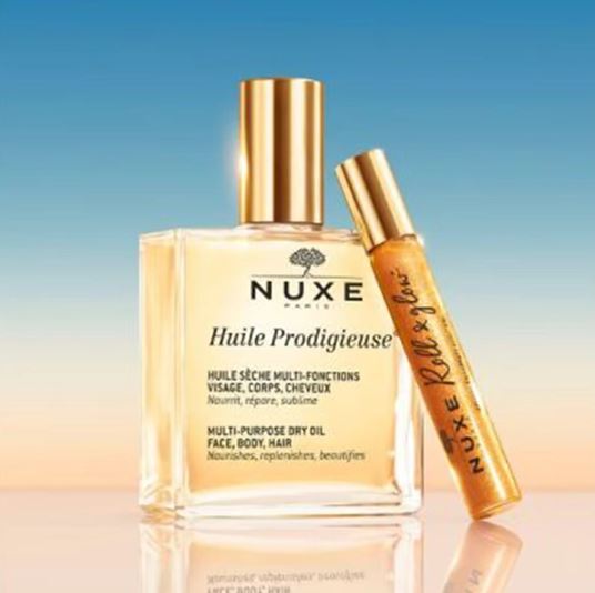 Nuxe Huile Prodigieuse multi-purpose dry oil with a smaller rollerball bottle on a gradient background