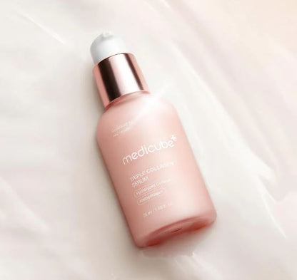 Pink skincare serum bottle with rose gold cap on a light pink background