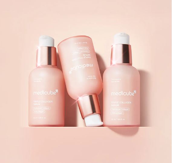 Four Medicube skincare bottles on a pink background