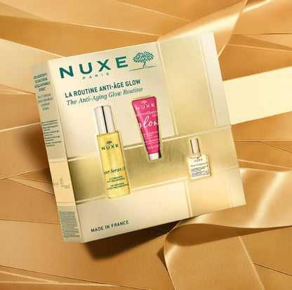Nuxe anti-aging skincare set with products and packaging on a gold background