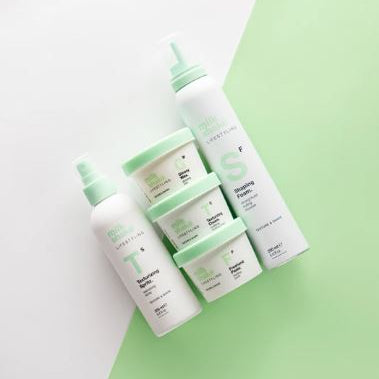 Set of skincare products with green caps on a light green background