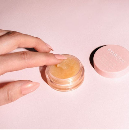 Hand interacting with a cosmetic product on a pink background