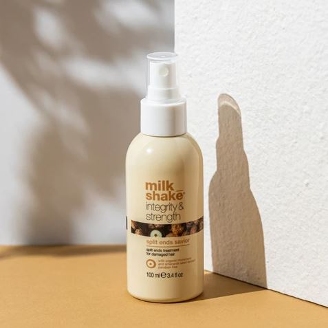 Milk Shake hair care product bottle on a wooden surface with a white wall background