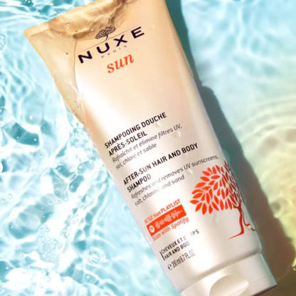 Nuxe after-sun shampoo tube on a blue water background