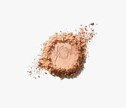 Pile of beige makeup powder with a brand logo on a white background