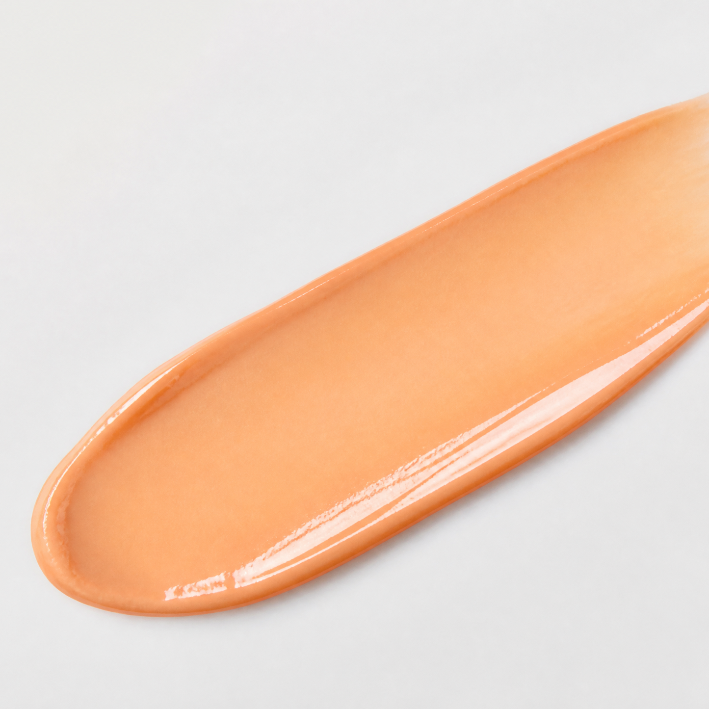 Orange smear of cream on a light gray background