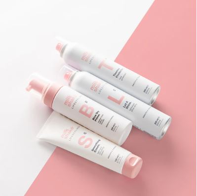Set of white bottles with pink caps on a pink and white background